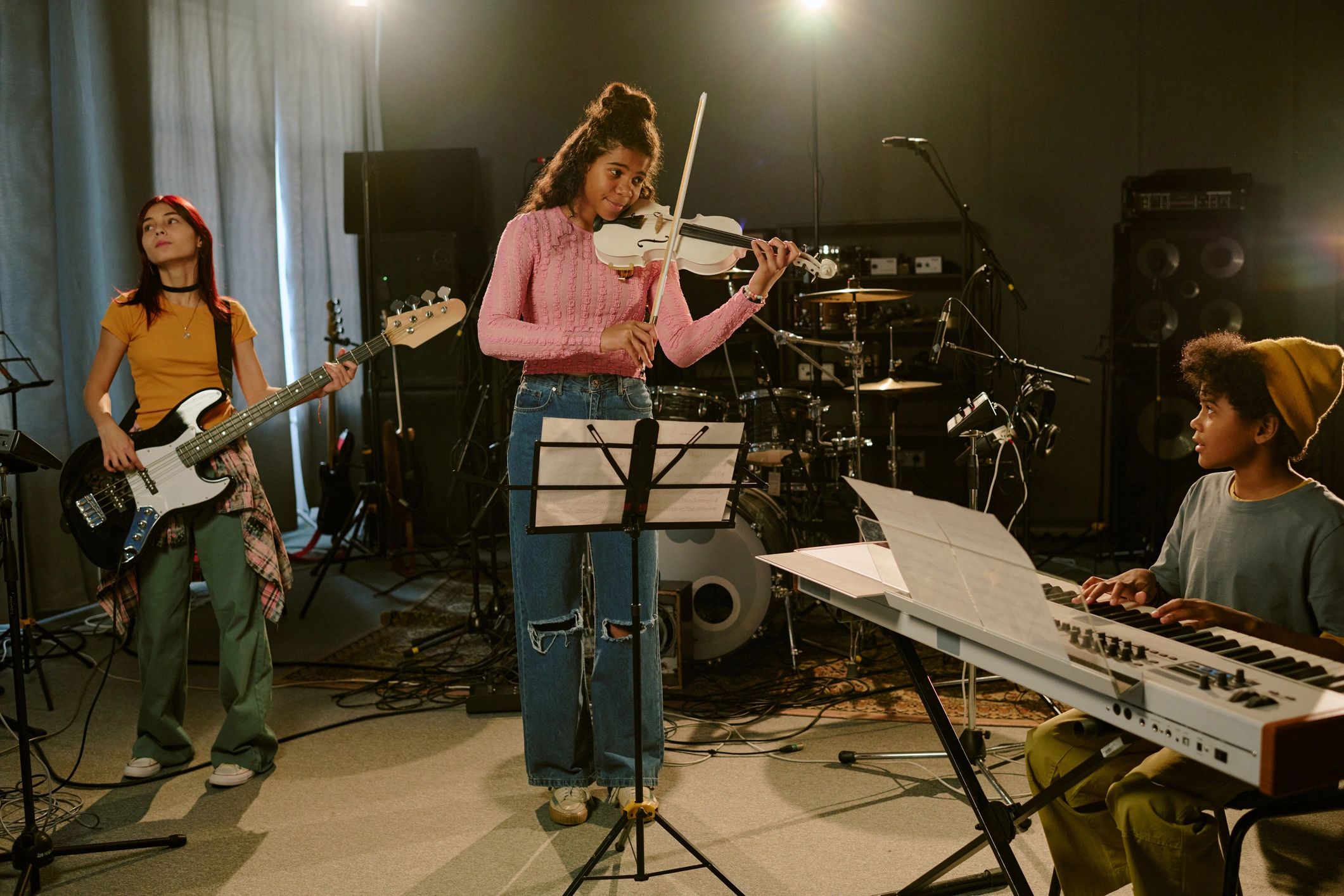 Teenage musicians rehearsing together in a studio